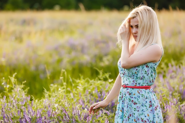 Outdoor-Porträt einer schönen blonden Frau mittleren Alters. attraktives sexy Mädchen in einem Feld mit Blumen