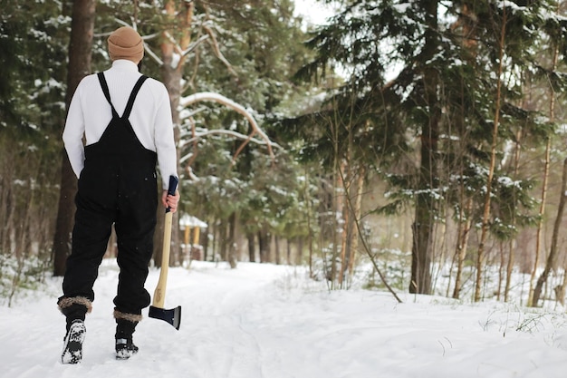 Outdoor-Porträt eines gutaussehenden Mannes in Mantel und Schal. Bärtiger Mann im Winterwald.