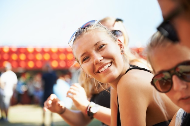 Outdoor-Porträt oder glückliche Frau bei einem Musikfestival im Urlaub, um sich beim Neujahrskarnevalspublikum oder bei Menschen mit Freiheitslächeln oder Jugendkultur für ein Konzert oder eine lustige Party zu entspannen