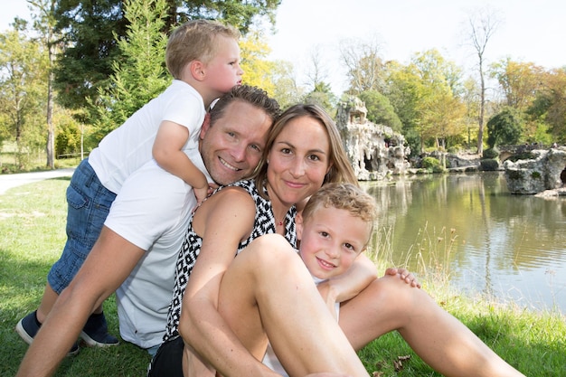 Outdoor-Porträt spielen in der Nähe von River Lake Outdoor-Park glückliche Familie Mutter, Vater und Kinder, Sohn