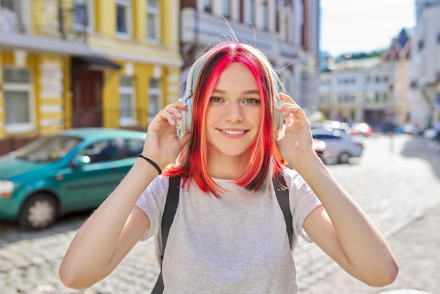 Outdoor-Porträt von Teenager-Mädchen, die Musik mit drahtlosen Kopfhörern hören