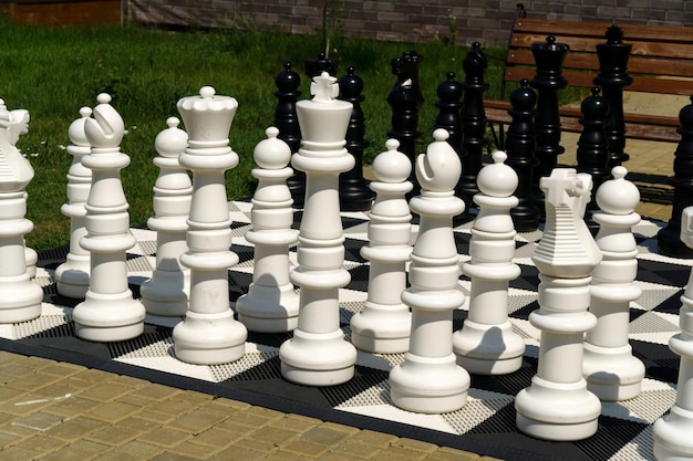 Outdoor-Schachbrett mit großen Plastikfiguren. Outdoor-Riesenschach. Freizeit und Aktivitäten