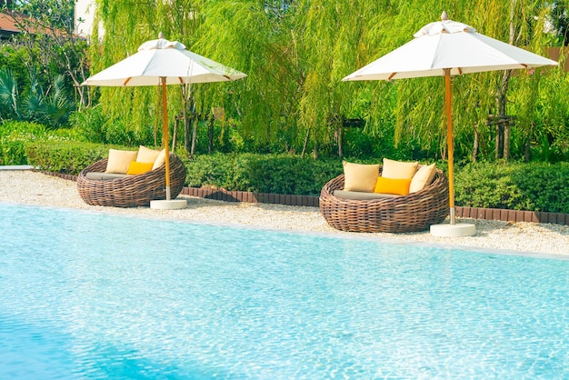 Outdoor-Terrassenstuhl mit Kissen und Sonnenschirm rund ums Schwimmbad - Urlaub und Urlaubskonzept