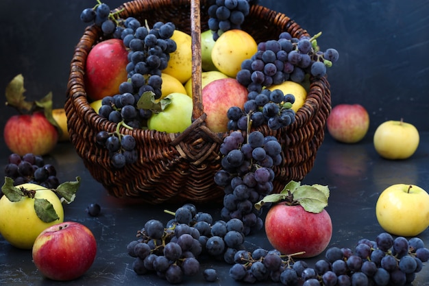 Outono ainda vida com maçãs e uvas localizadas, maçãs e uvas em uma cesta