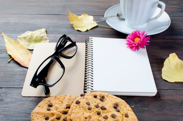 Outono ainda vida com xícara de chá, biscoitos, copos e folhas.