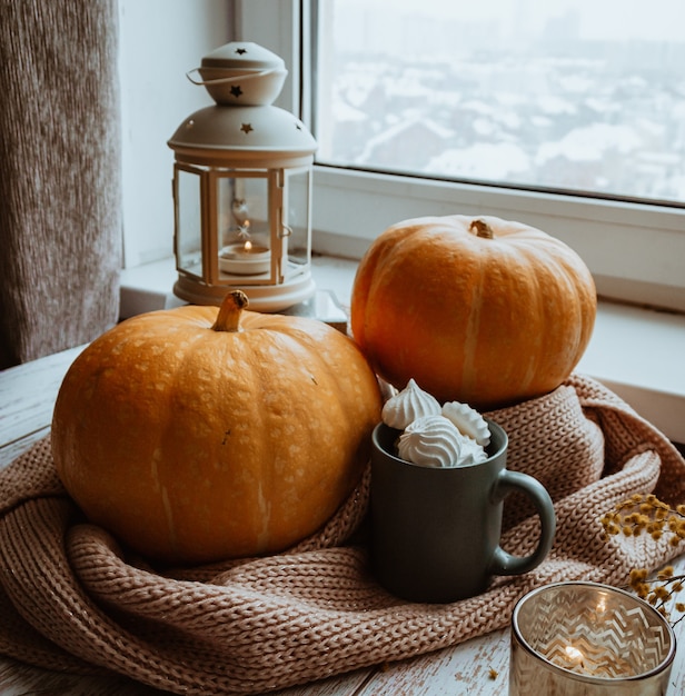Outono ainda vida no parapeito de uma janela, abóboras e uma lanterna com velas, celebração do Halloween.