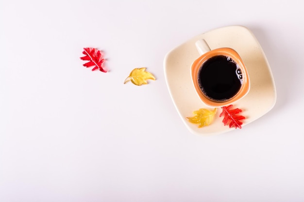 Outono ainda xícara de café preto e folhas coloridas em um fundo rosa Vista superior Copiar espaço