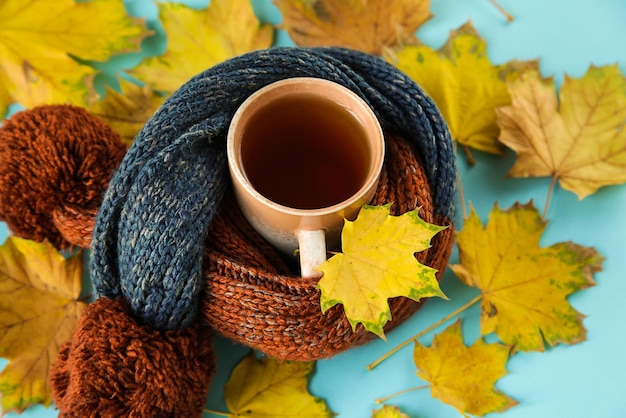 Outono deixa xícara de chá, cachecol quente na mesa de madeira