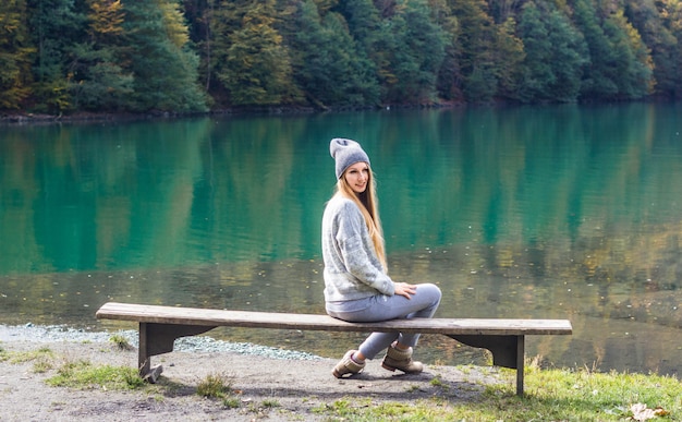 Outono menina bonita posando perto do lago de montanha. paisagem de outono na floresta.