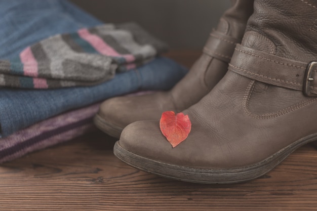 Outono roupa feminina. Conjunto de roupas, sapatos e saia vermelha em fundo de madeira