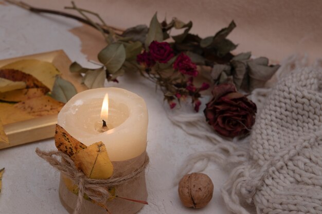 Outono vintage natureza morta com folhas caídas, velas e um cobertor de malha. Conceito de atmosfera de outono