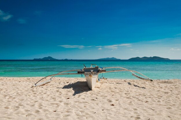 Foto outrigger-boot am strand an einem sonnigen tag