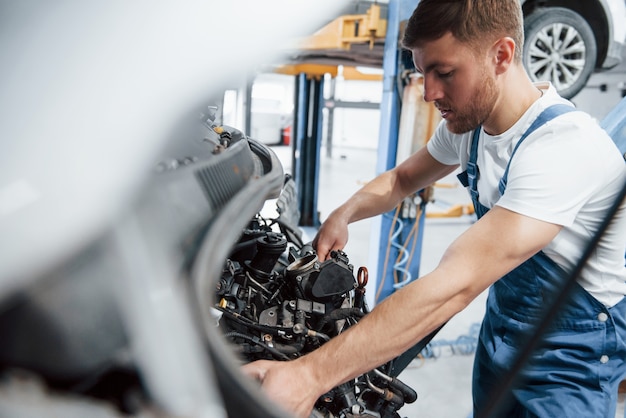 Outro dia agitado. Empregada com uniforme azul trabalha no salão automóvel.