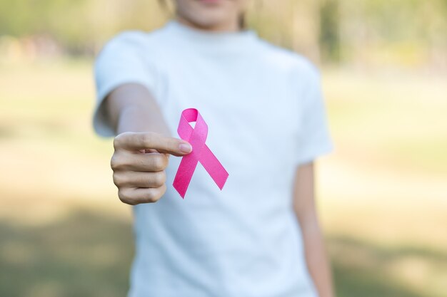 Foto outubro, mês de conscientização sobre o câncer de mama, adulto mulher segurando uma fita rosa