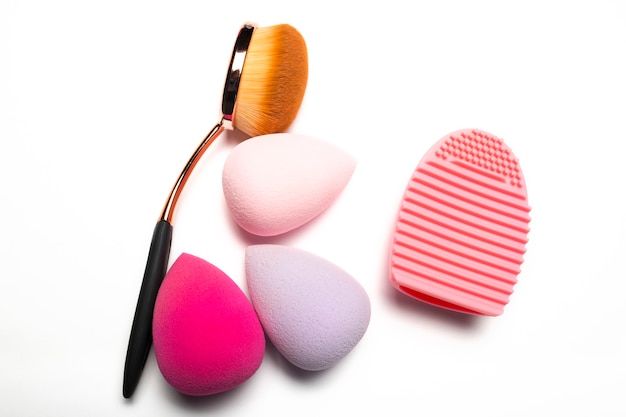 Oval Pinsel und Beauty Blender mit Pinselreiniger auf weißem Hintergrund