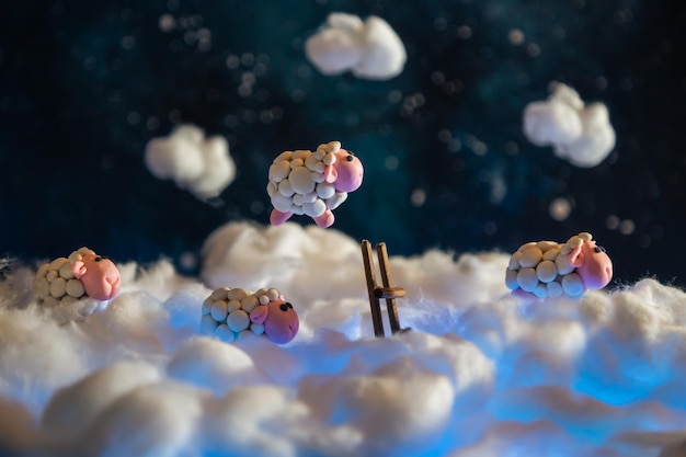 Foto ovelhas de plástico bonitas a saltar por cima de uma cerca nas nuvens.