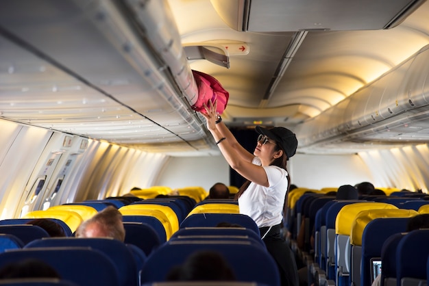 Overhead-Spinde der Reisenden Frau offen auf dem Flugzeug