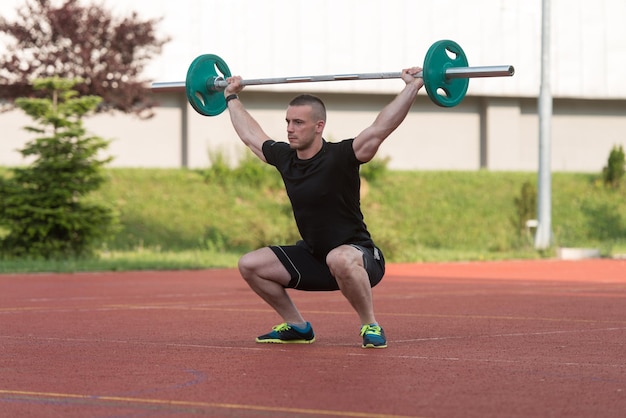 Overhead-Squat-Übung im Freien, die von einem jungen Mann durchgeführt wird