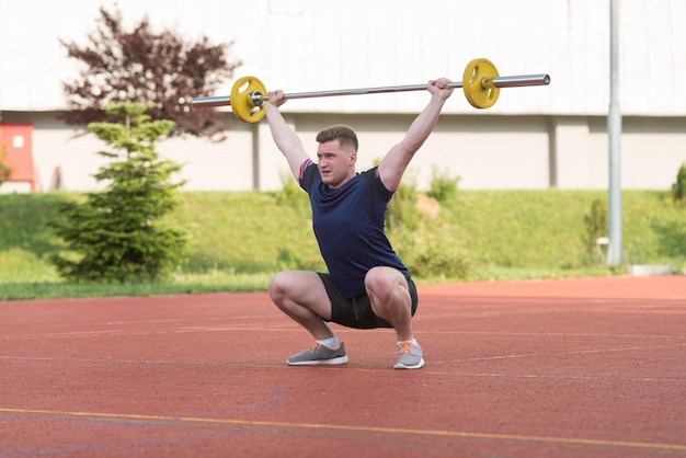 Overhead Squat ejercicio al aire libre realizado por un hombre joven