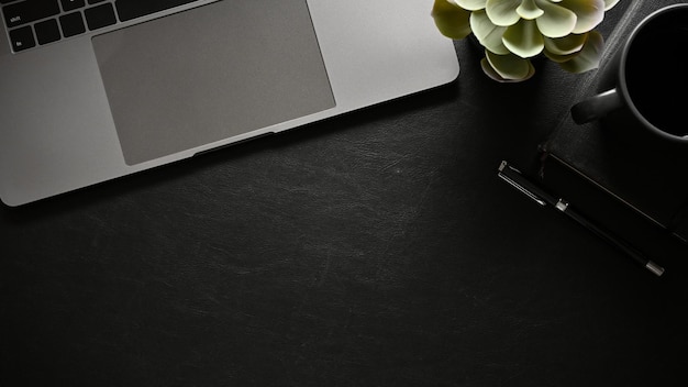 Overhead Um espaço de cópia na mesa de trabalho preta moderna com acessórios para laptop e escritório