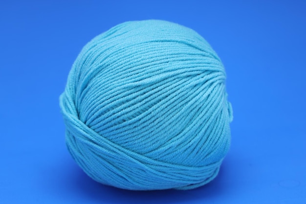 Ovillo de lana azul sobre fondo azul. Foto de alta calidad