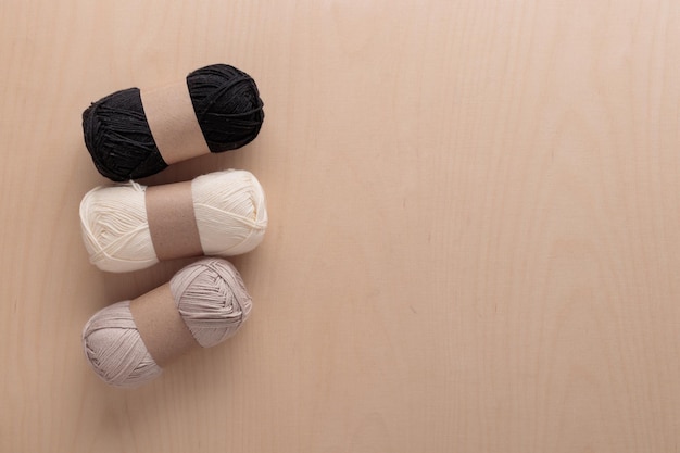 Ovillos de hilo de algodón para tejer a ganchillo hecho a mano sobre un fondo de madera de color claro
