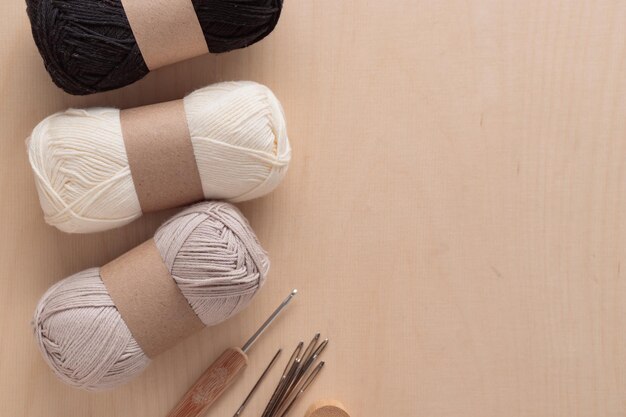 Ovillos de hilo de algodón para tejer a ganchillo hecho a mano sobre un fondo de madera de color claro