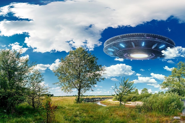 OVNI un platillo alienígena flotando sobre el campo flotando inmóvil en el aire Objeto volador no identificado invasión extraterrestre vida extraterrestre viaje espacial nave espacial técnica mixta