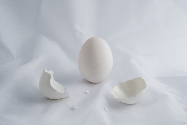 Ovo branco e casca de ovo em tecido branco