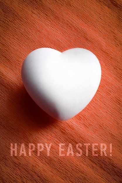 Ovo branco em forma de coração com as palavras feliz Páscoa