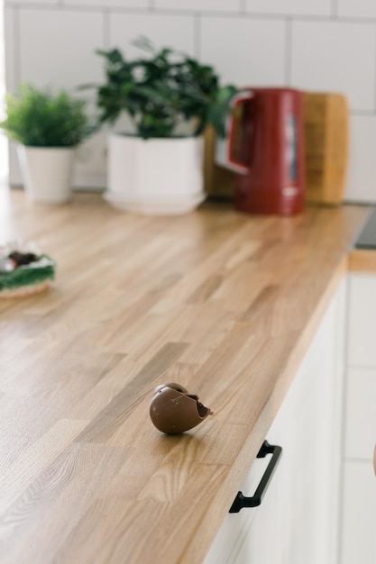 Ovo de chocolate quebrado na mesa de madeira na foto vertical da cozinha com espaço de cópia e lugar vazio para texto