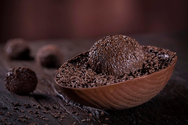 Ovo de Páscoa de chocolate recheado com brigadeiro em fundo de madeira rústico