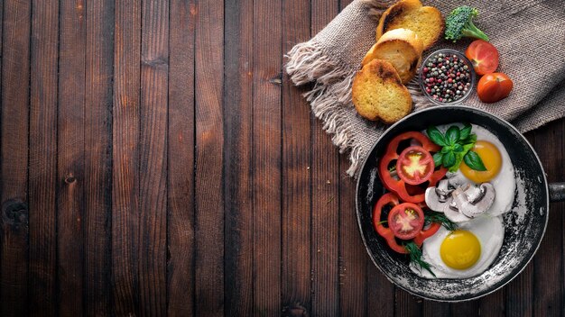 Ovo frito com ervas torradas pão e legumes em uma frigideira Vista superior Espaço livre