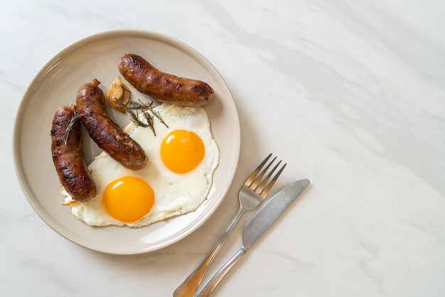 Ovo frito duplo caseiro com linguiça de porco frita - no café da manhã