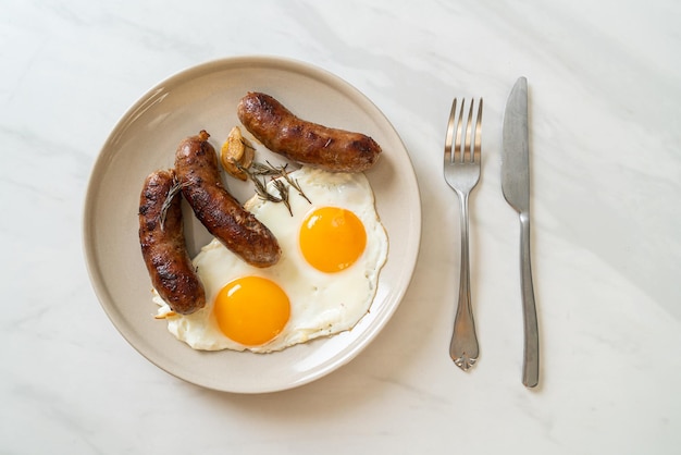 Ovo frito duplo caseiro com linguiça de porco frita - para o café da manhã