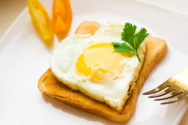 Ovo frito em forma de coração no café da manhã