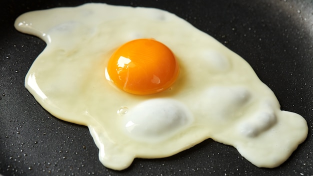 Foto ovo frito em uma panela preta