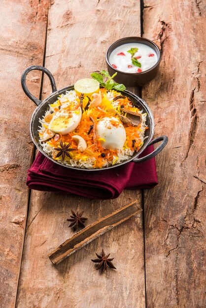 Ovo indiano biryani ou arroz anda servido em kadhai ou kadai com molho de iogurte, foco seletivo