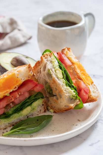 Ovo no sanduíche com abacate, espinafre e tomate no café da manhã