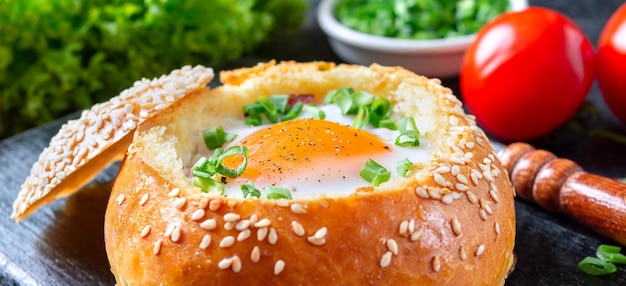 Ovos assados em um pão com queijo de presunto e cebola verde closeup Banner fundo preto