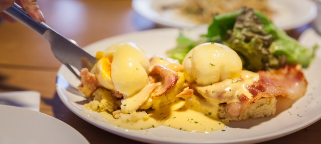 Ovos Benedict, bacon e molho holandês