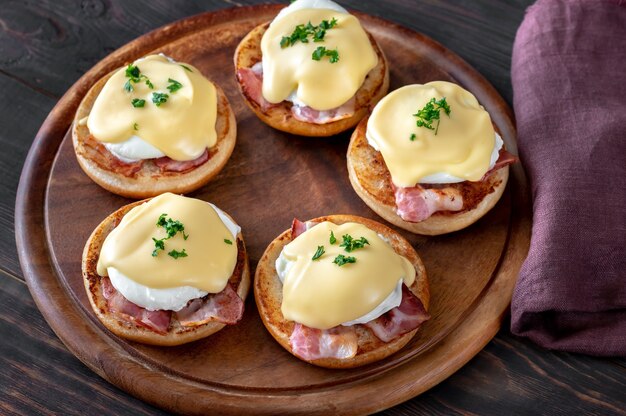 Ovos Benedict com bacon na tábua de madeira