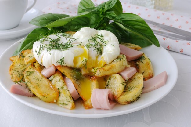 Ovos Benedict deliciosos com batatas fritas e bacon no café da manhã.