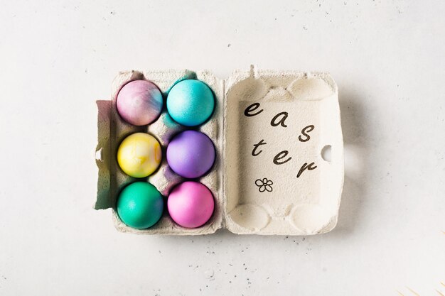 Ovos coloridos na caixa tema de Páscoa e primavera na vista superior do espaço de cópia de fundo branco
