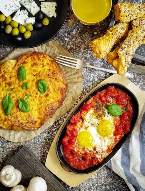 ovos com tomate, queijo, azeitonas, suco de laranja e pão