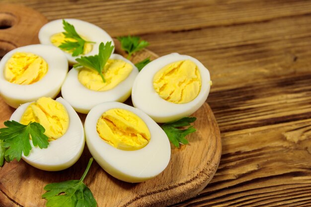 Ovos cozidos com salsa na tábua em uma mesa de madeira