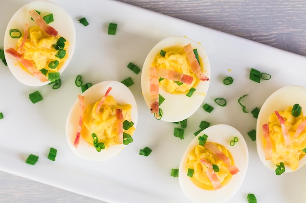 Ovos cozidos guarnecidos com cebolinha e bacon.