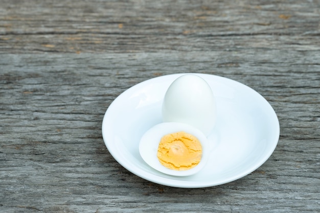 Foto ovos cozidos. ovos cozidos em placa de cerâmica branca na mesa de madeira.
