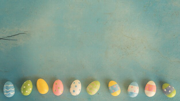 Ovos da páscoa coloridos no fundo de madeira da cor pastel com espaço.