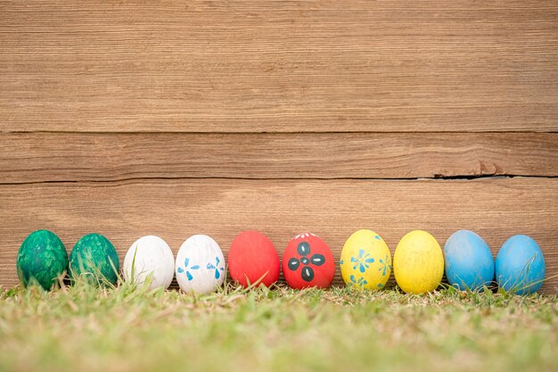 Ovos da páscoa na grama contra de madeira velho borrado.